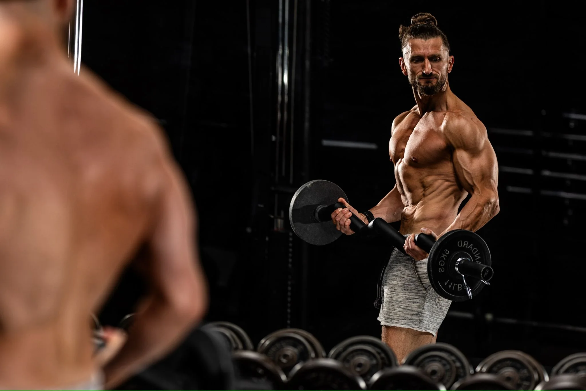 Personal trainer Nick Dootson training with dumbbells in a dramatically lit studio